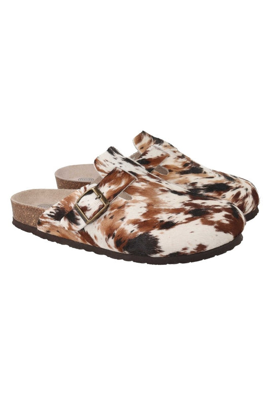 Pair of cow print clogs with a buckle on a white background