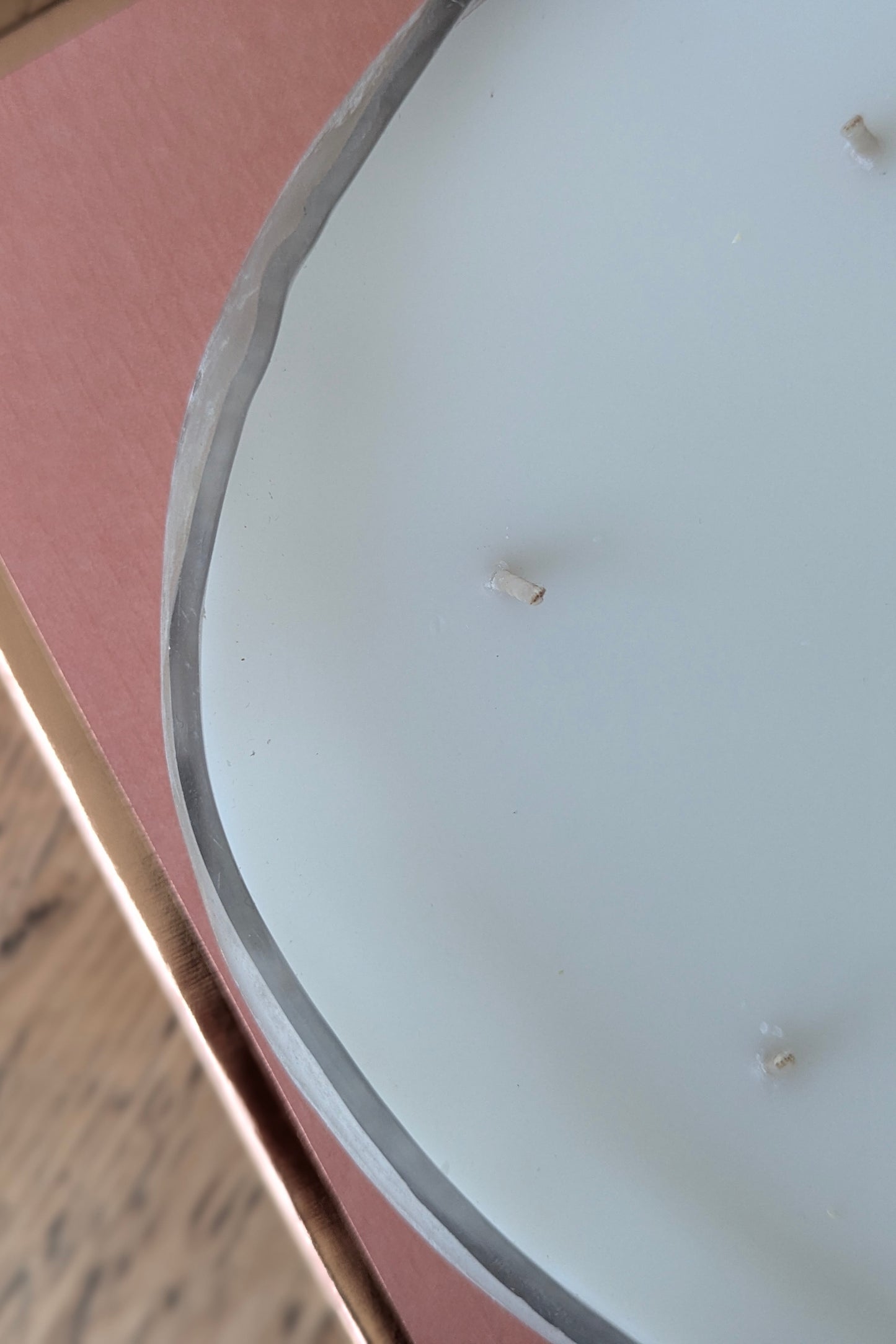 Close-up of a white candle on a pink surface