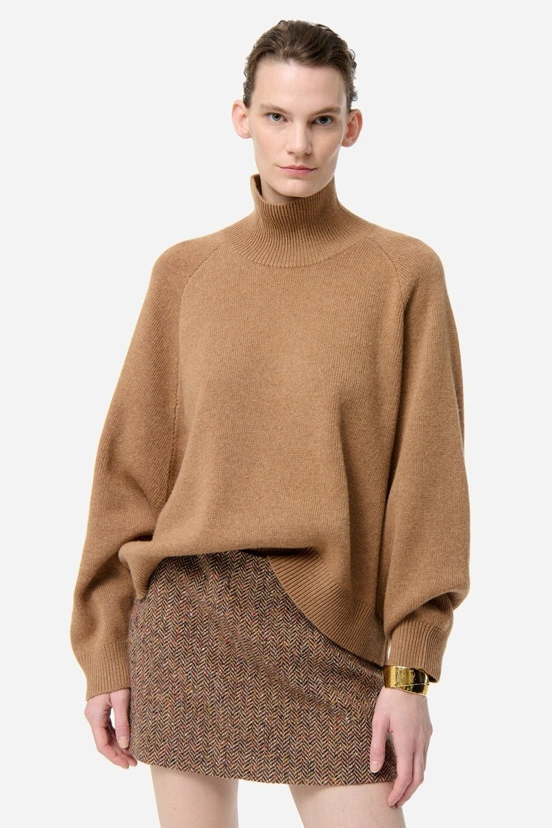 Woman wearing a brown sweater and skirt on a white background
