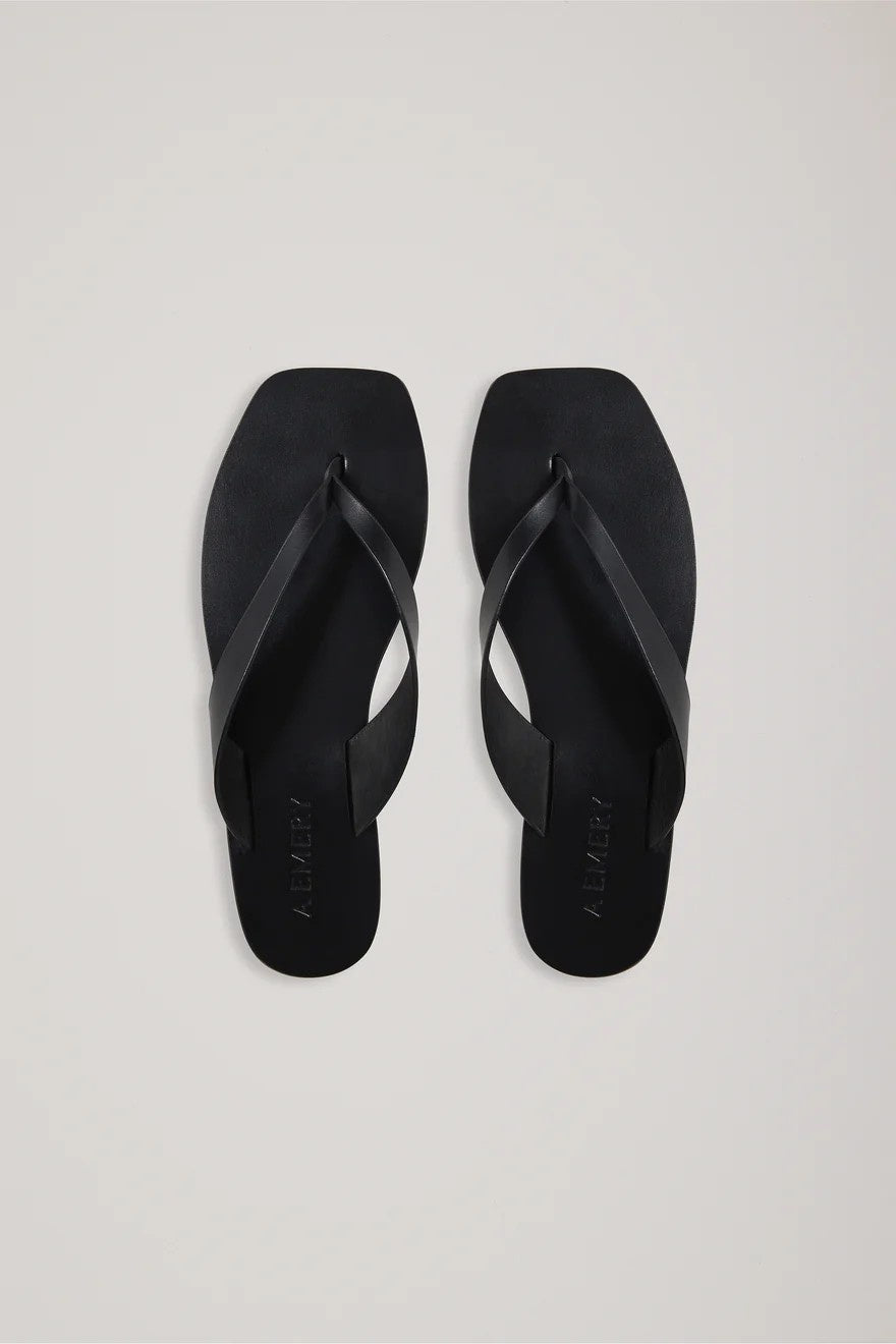 Pair of black flip-flops on a light gray background