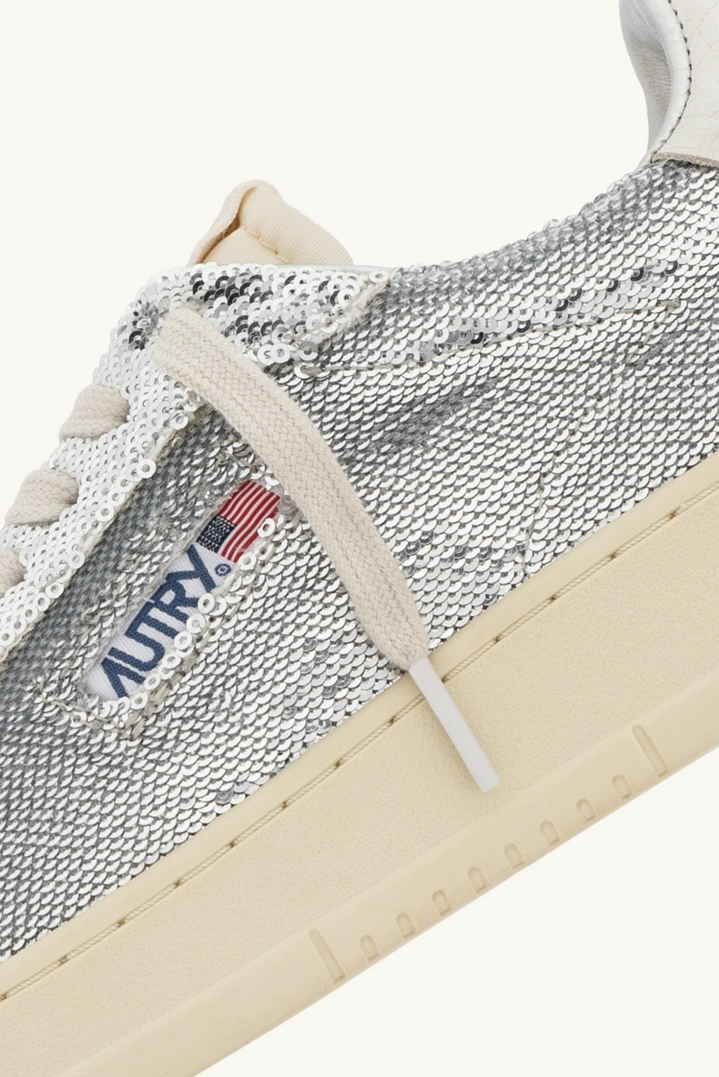 Silver Autry dallas sneaker with white laces and Autry logo on a white background