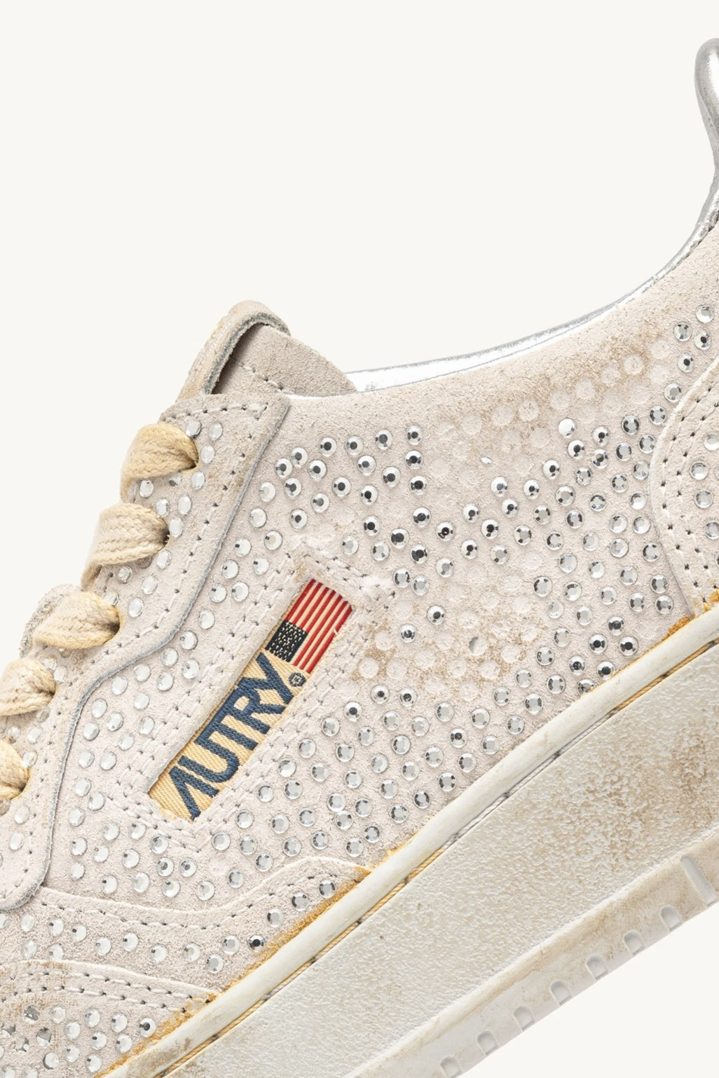 White sneaker with rhinestone embellishments and a visible brand logo on a white background