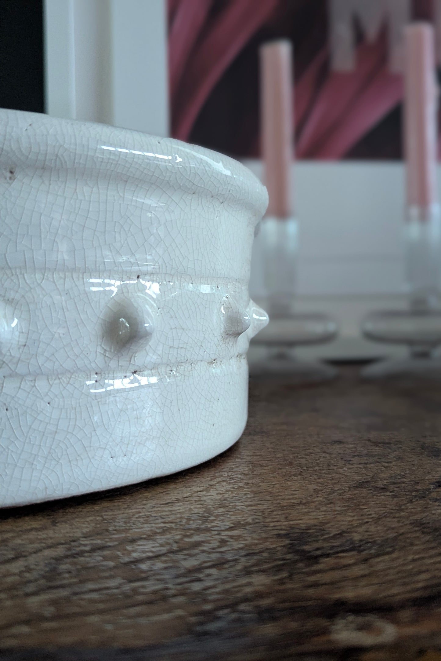 Close-up of a white ceramic bowl with a textured surface on a wooden surface.
