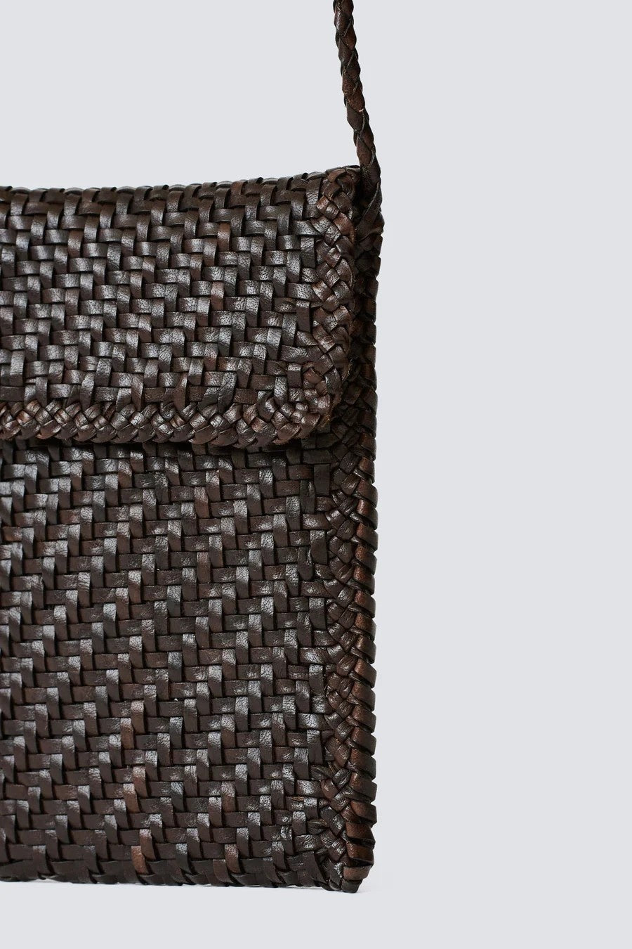 Close-up of a woven brown bag on a light gray background