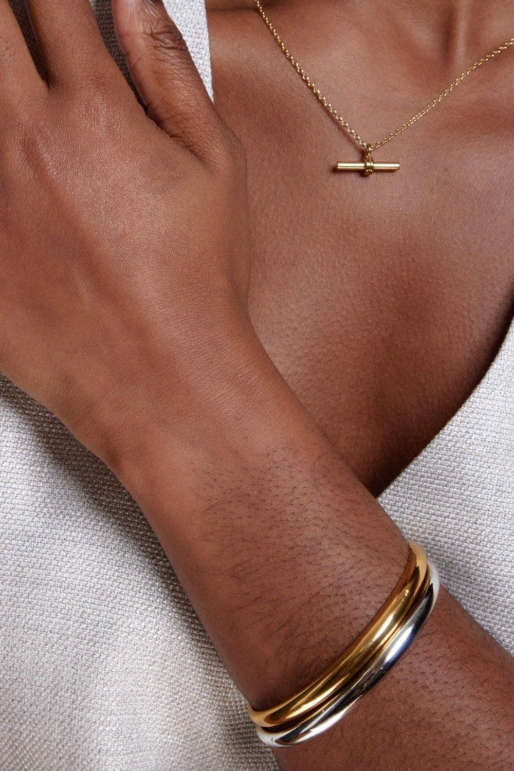 Gold and silver bracelets and necklace worn by a woman