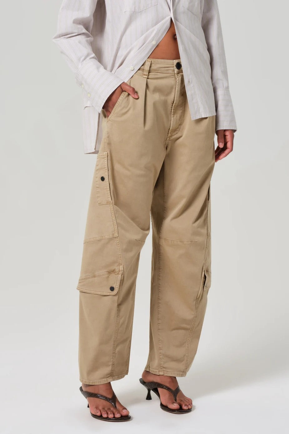 Person wearing beige cargo pants on a white background