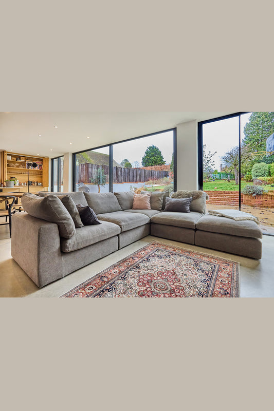 Modern living room with a large grey sectional sofa and large windows.