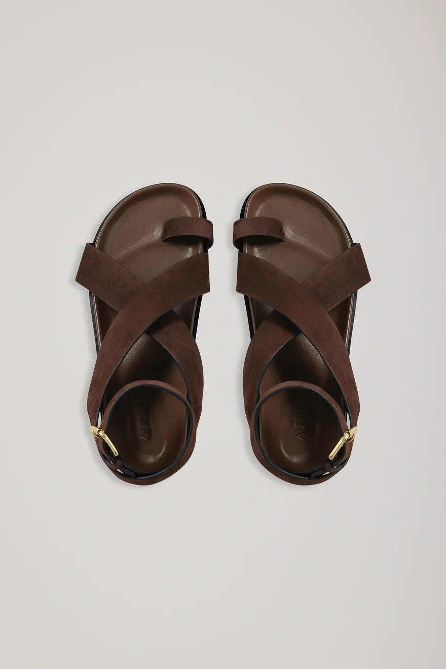 Pair of brown sandals on a light gray background