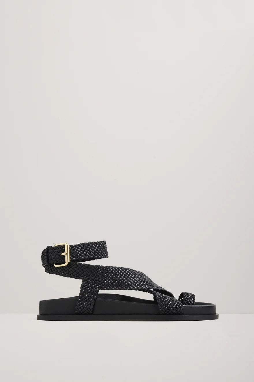 Black woven sandal with a gold buckle on a light gray background
