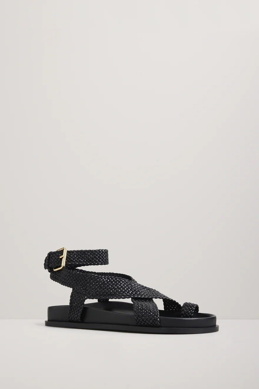 Black woven sandal with a gold buckle on a light gray background