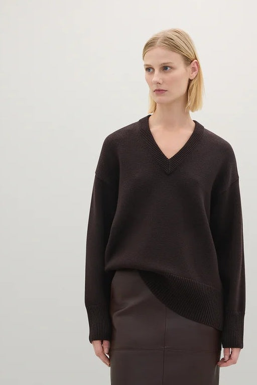 woman in brown v neck jumper and brown skirt
