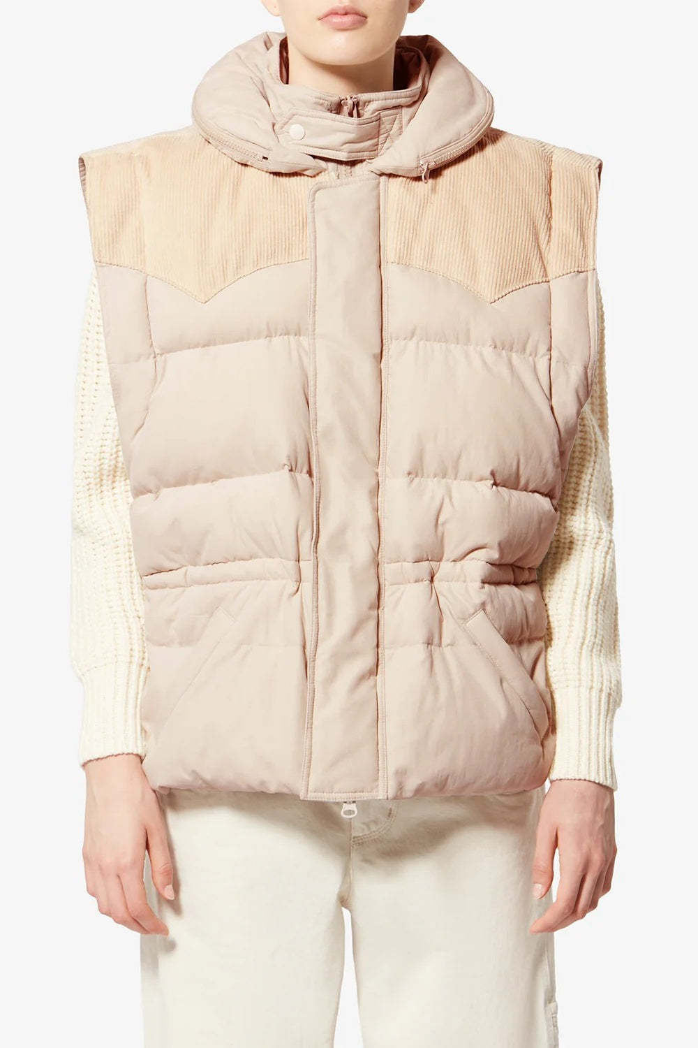 Person wearing a beige and white puffer vest with a plain background