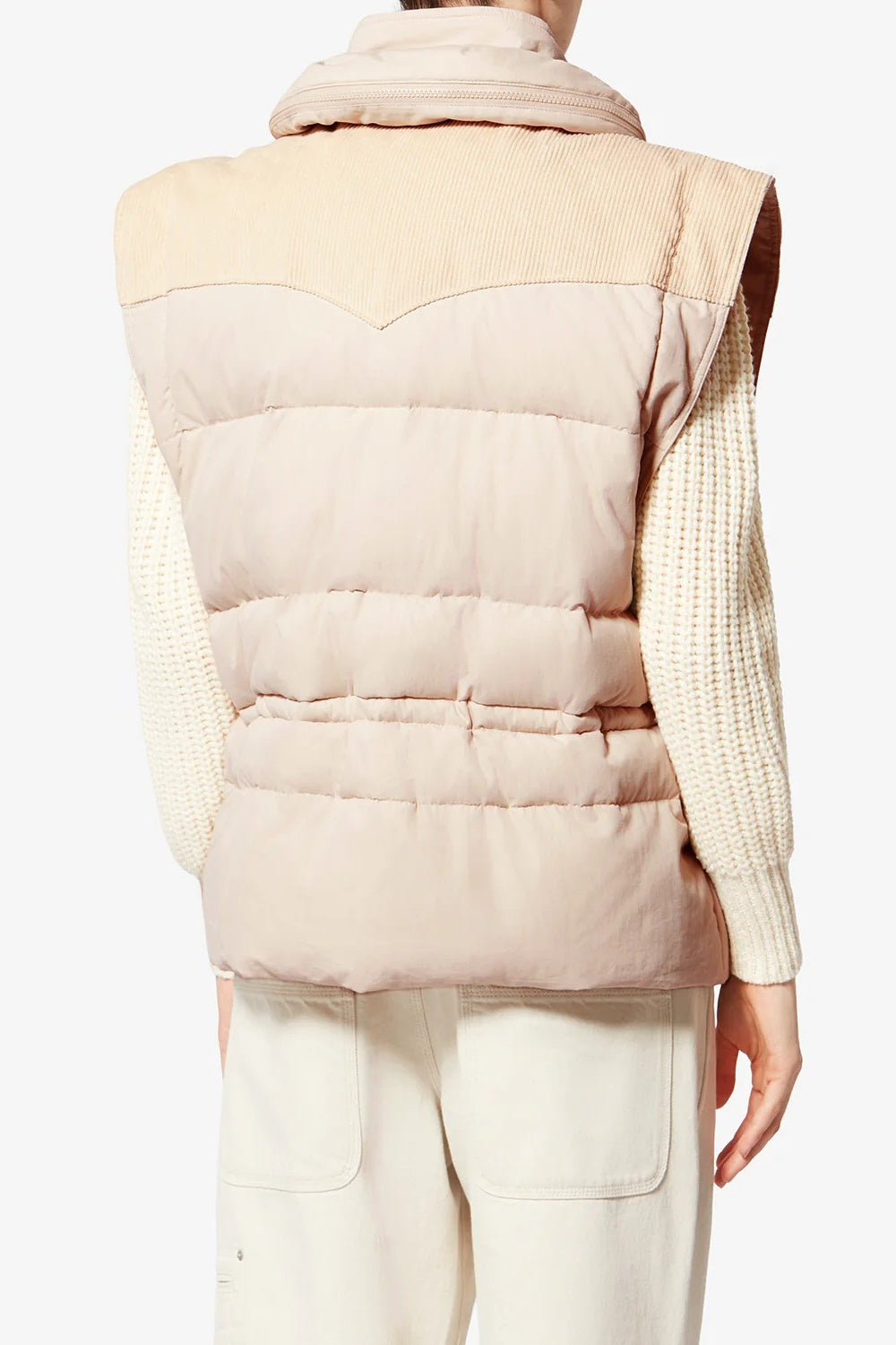 Beige puffer vest worn by a person on a white background