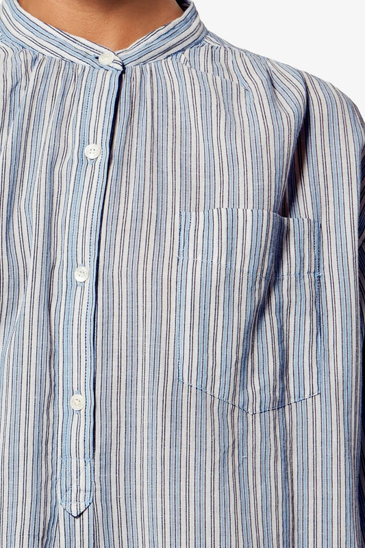 Close-up of a blue and white striped shirt with buttons and a pocket.