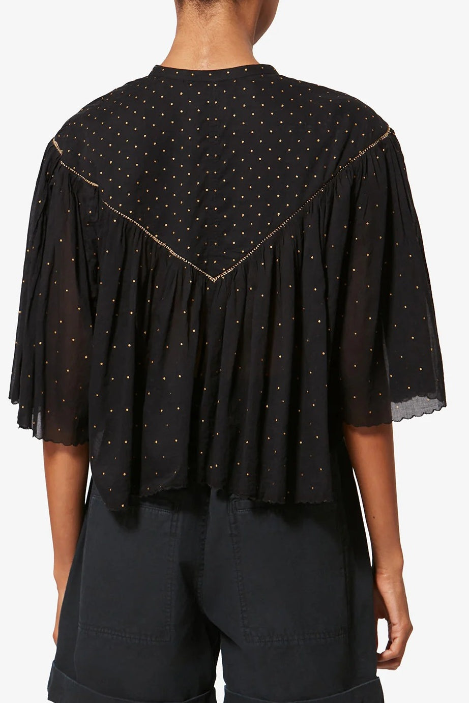 Black blouse with gold trim on a white background
