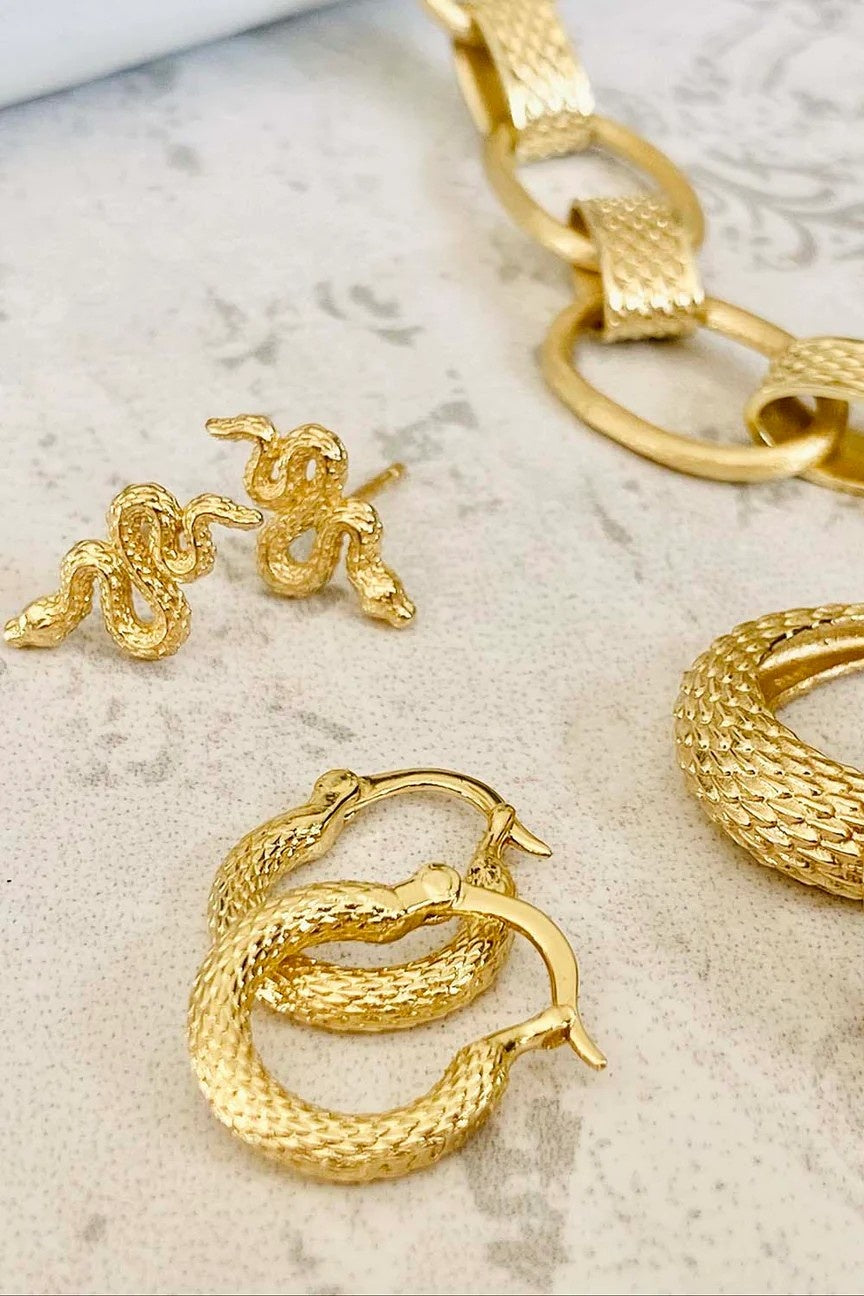 snake and hoop earrings on marble table