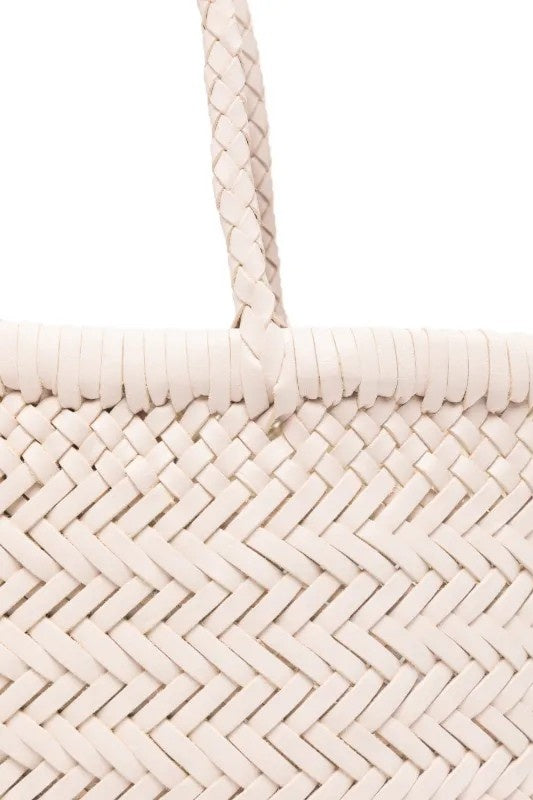 Close-up of a woven beige bag with braided handles on a white background