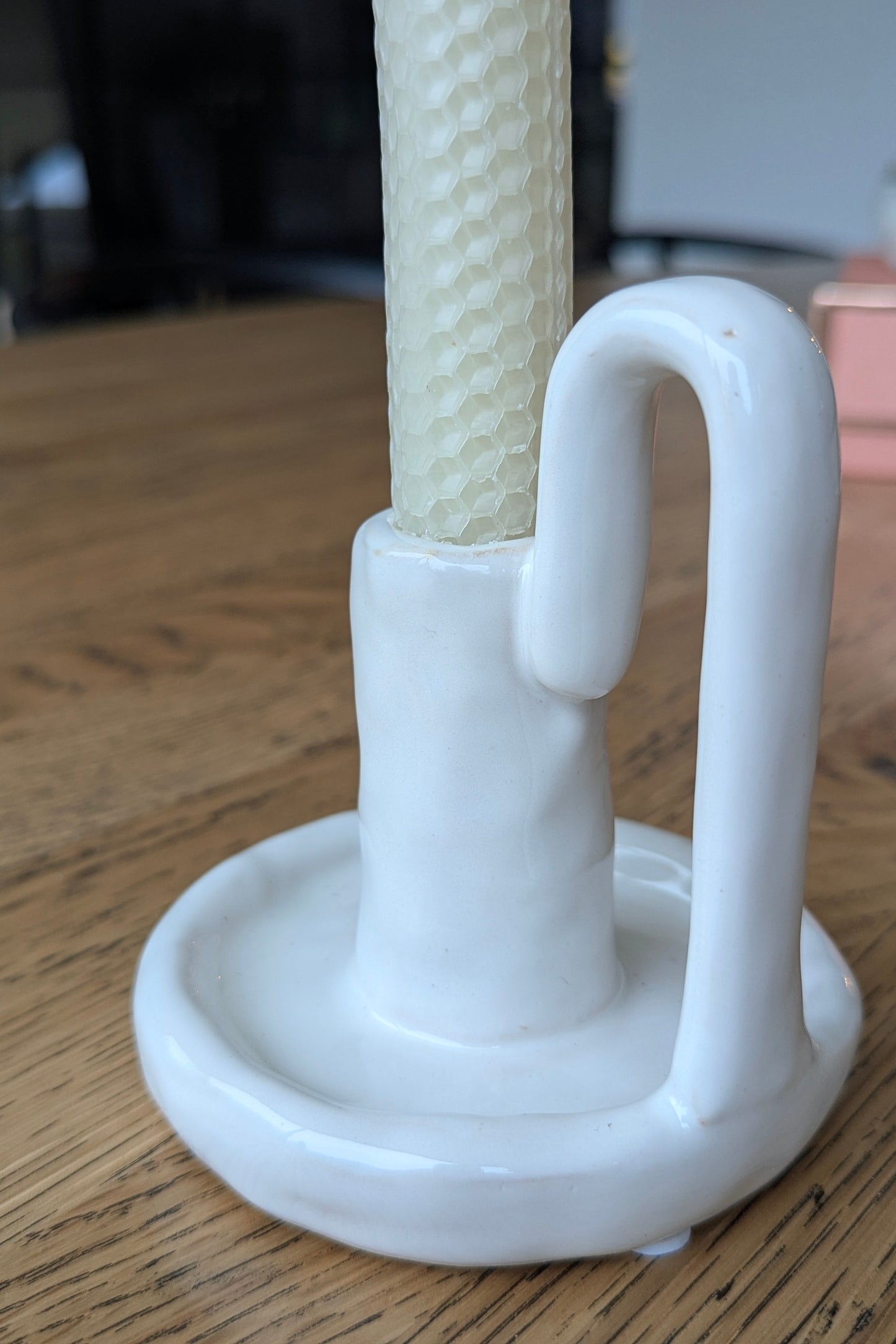 White plastic holder with a textured white rod on a wooden surface