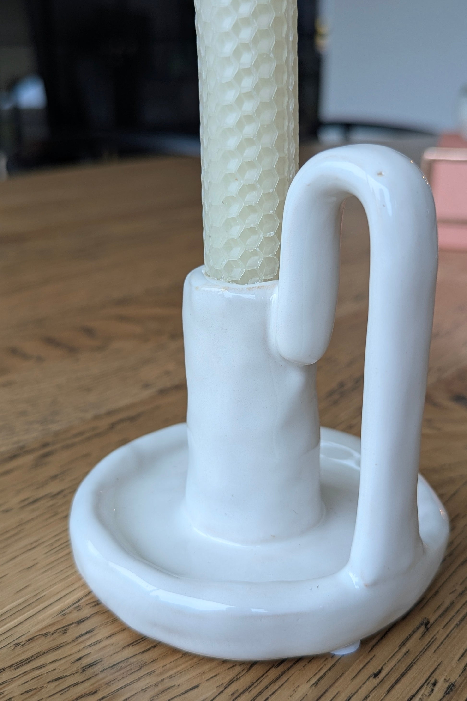 White plastic holder with a textured white rod on a wooden surface