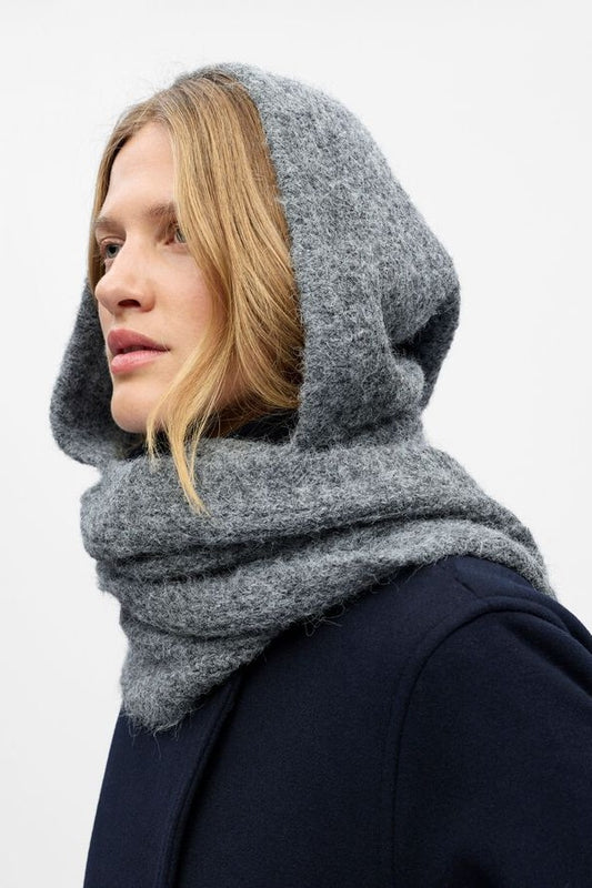 Person wearing a grey hooded scarf against a white background
