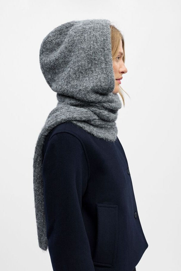 Person wearing a grey hooded scarf on a white background