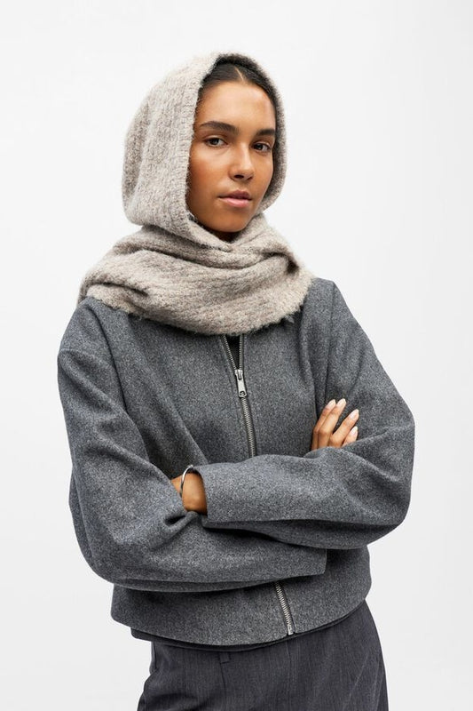 Person wearing a beige hooded scarf on a white background