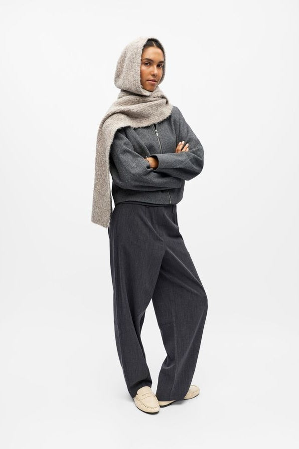 Person wearing a beige hooded scarf on a white background