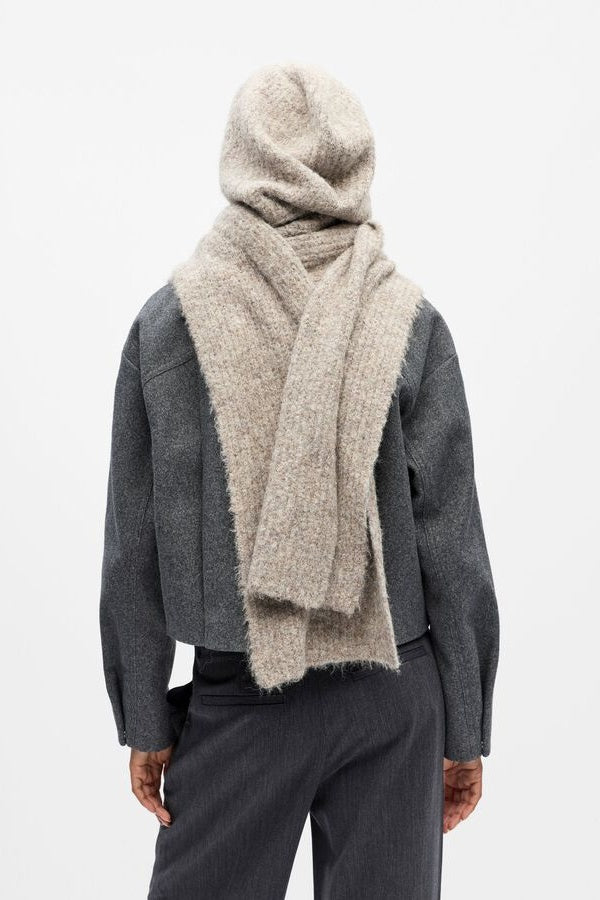 Person wearing a grey hooded scarf on a white background