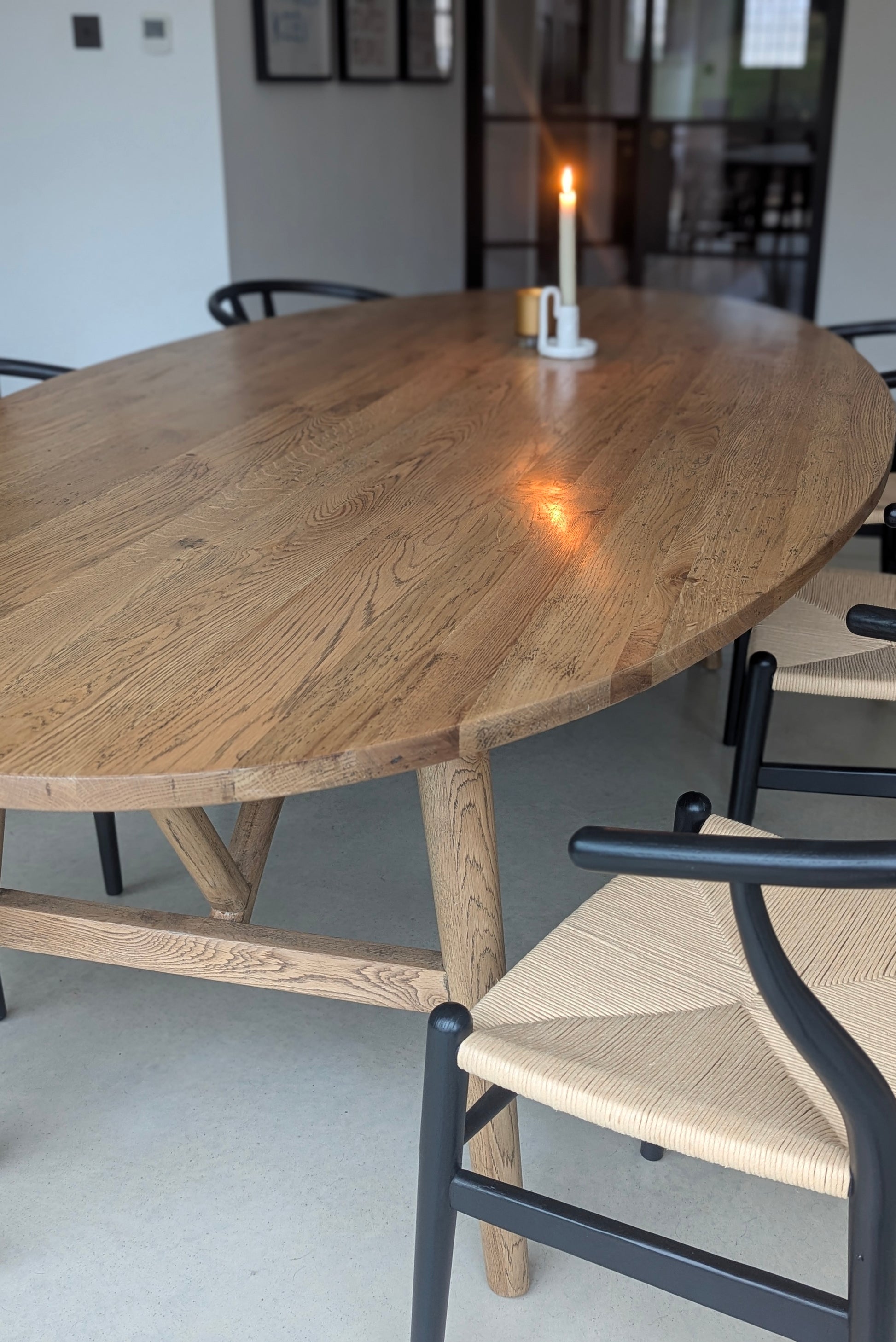 Wooden dining table with a candle and chairs in a room setting