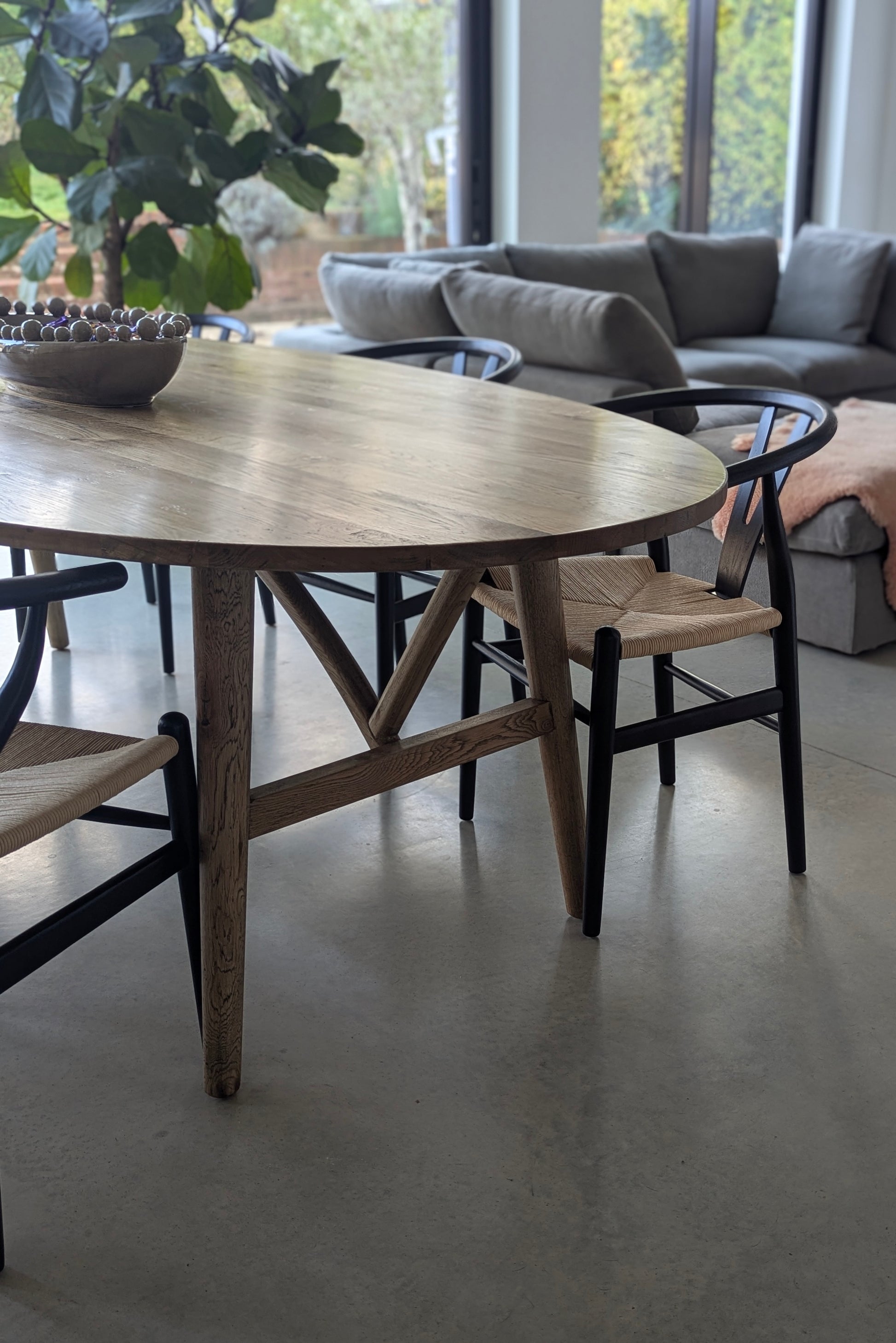 Wooden dining table with chairs in a modern living room setting