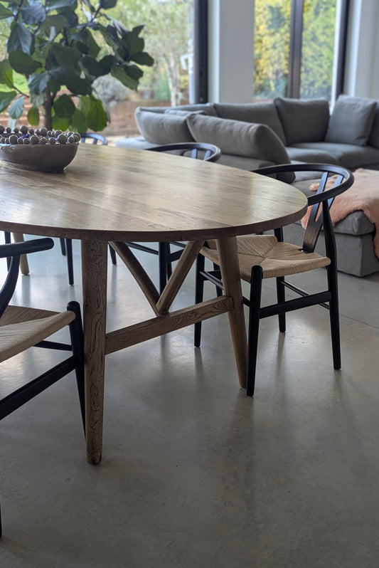 Wooden dining table with chairs in a modern living room setting