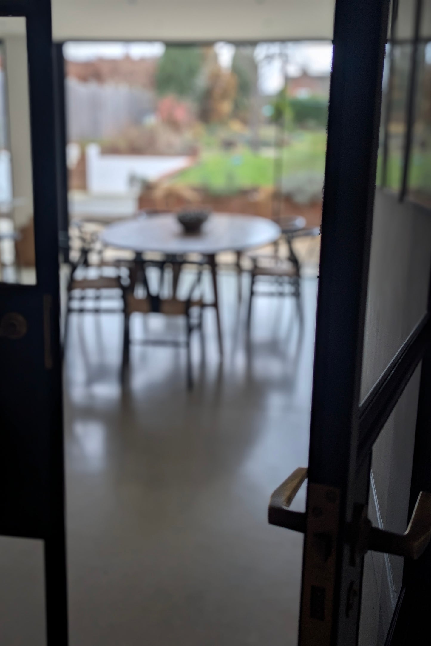 Dining area with a table and chairs through a glass door