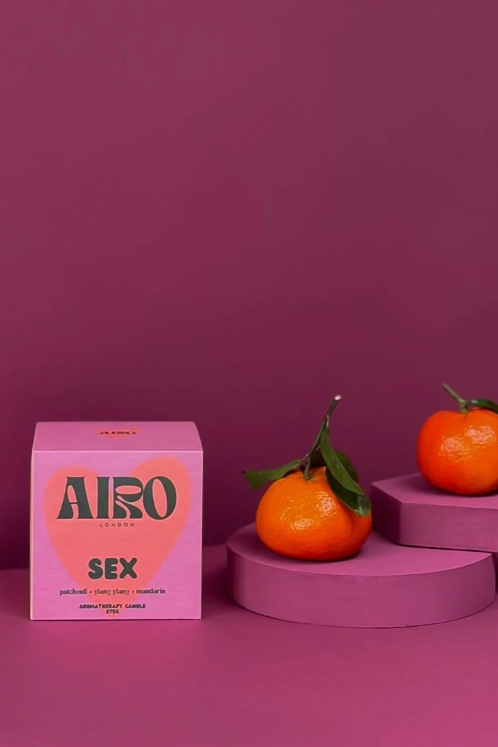 Pink 'Airo' product box with clementines on a purple platform against a purple background