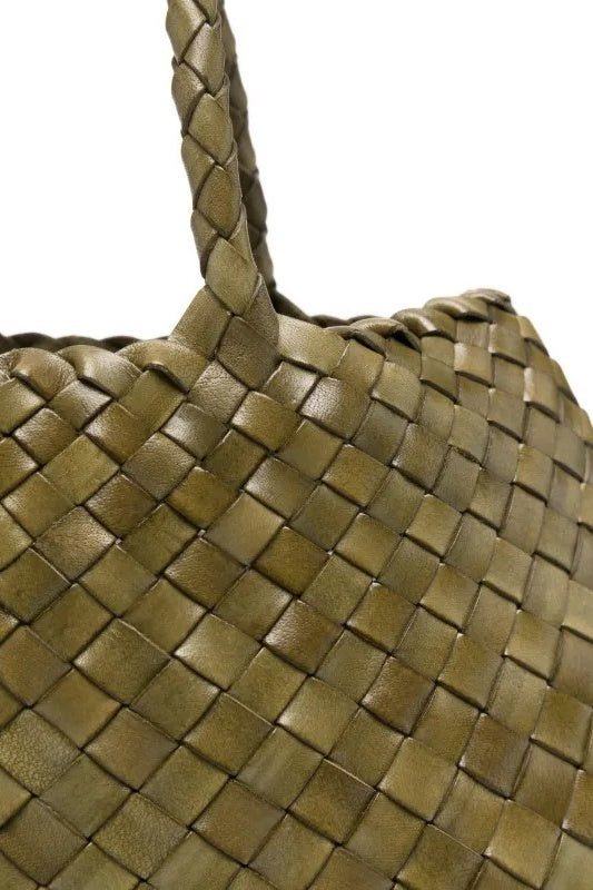 Close-up of a woven green leather handbag on a white background