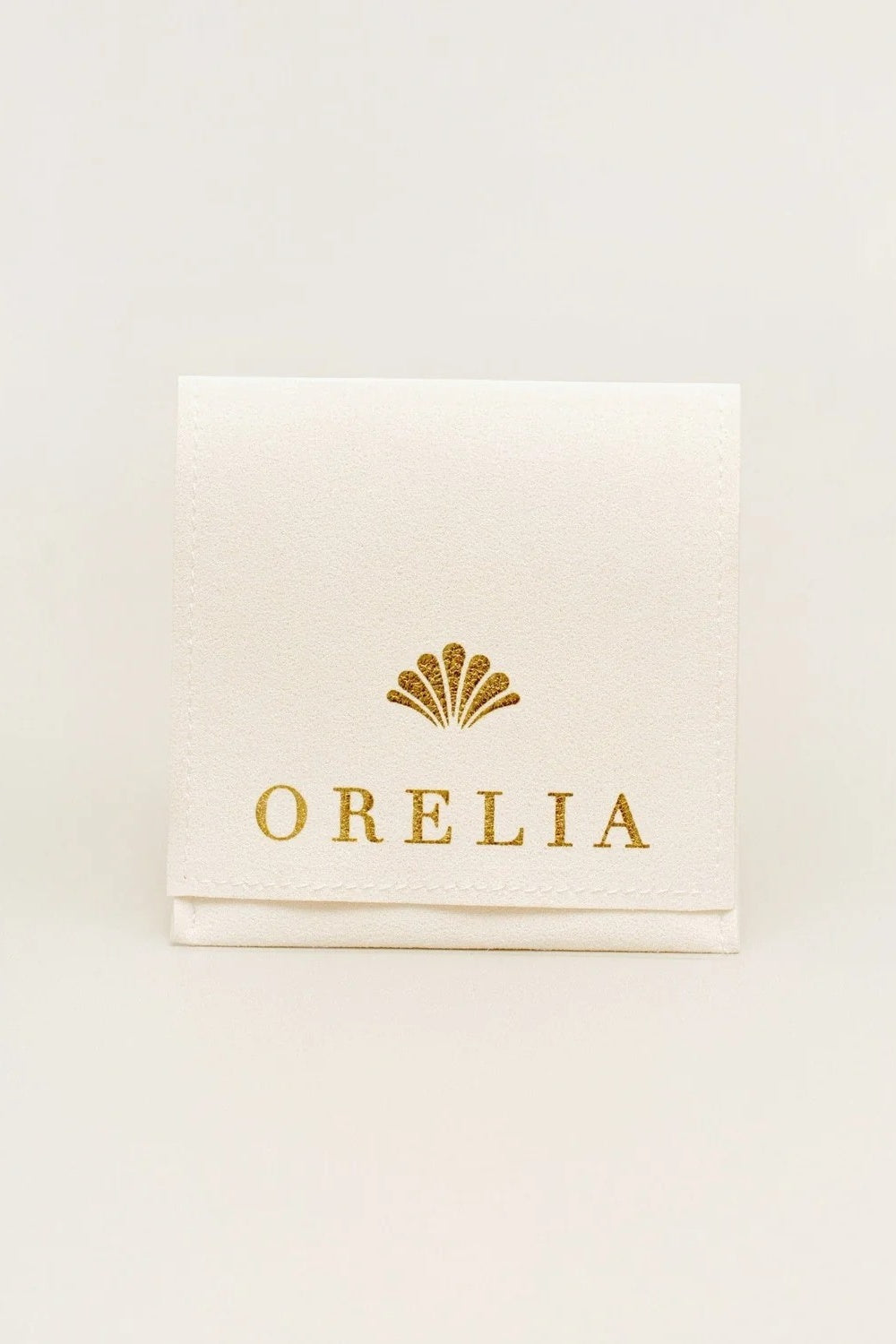 Pouch with gold 'ORELIA' logo on a light beige background