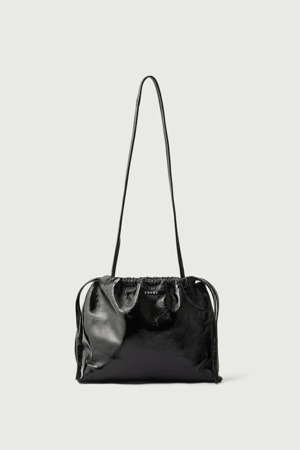 Black handbag with a strap on a light gray background