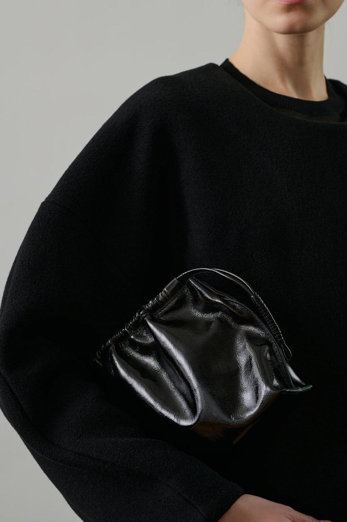 Black sweater with a black bag on a grey background