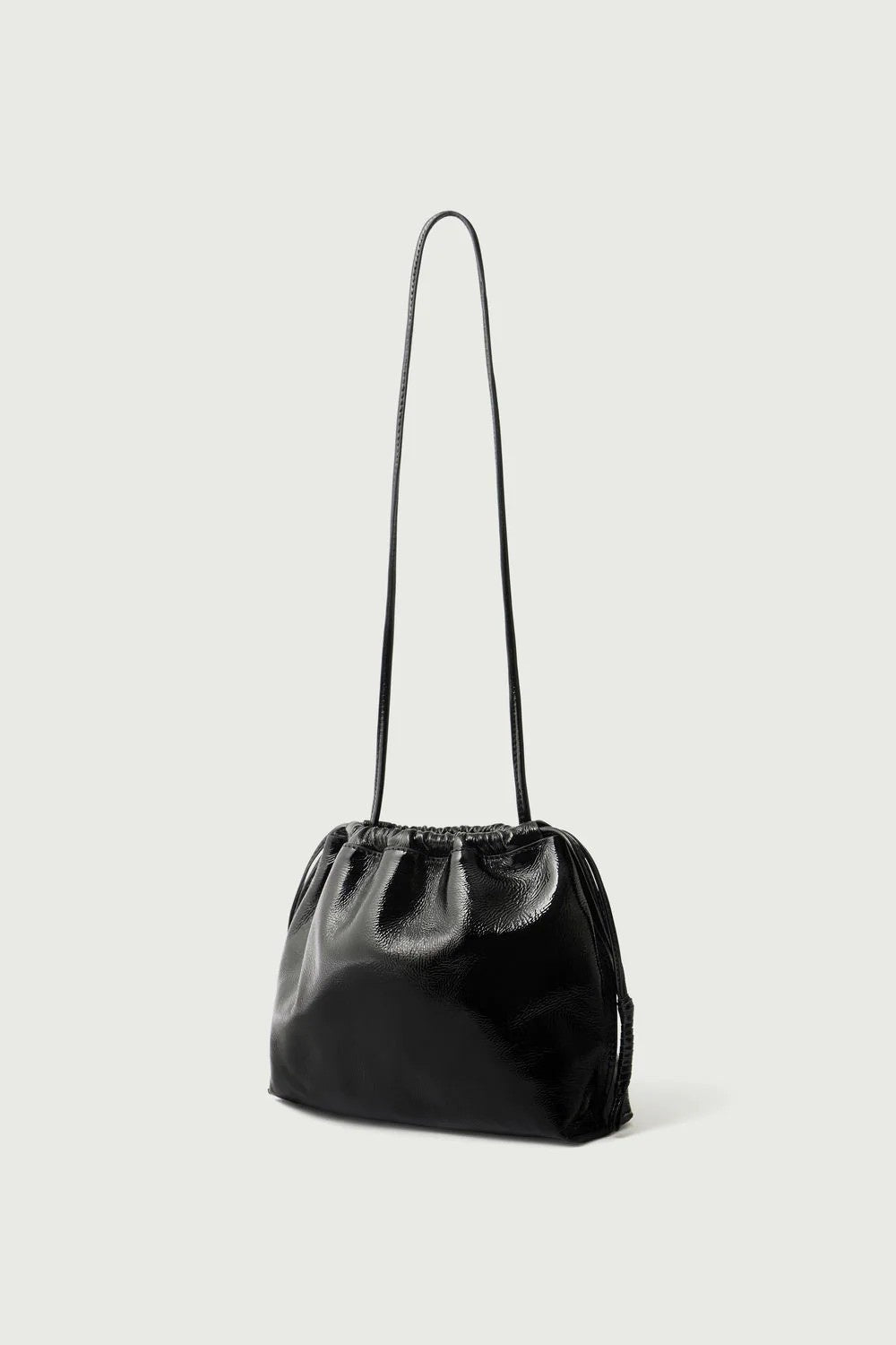 Black handbag with a strap on a light gray background