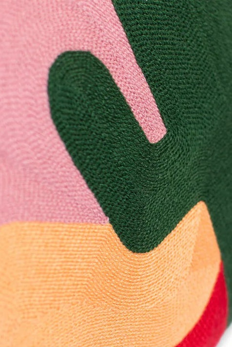 Close-up of a colorful fabric with pink, green, orange, and red sections.