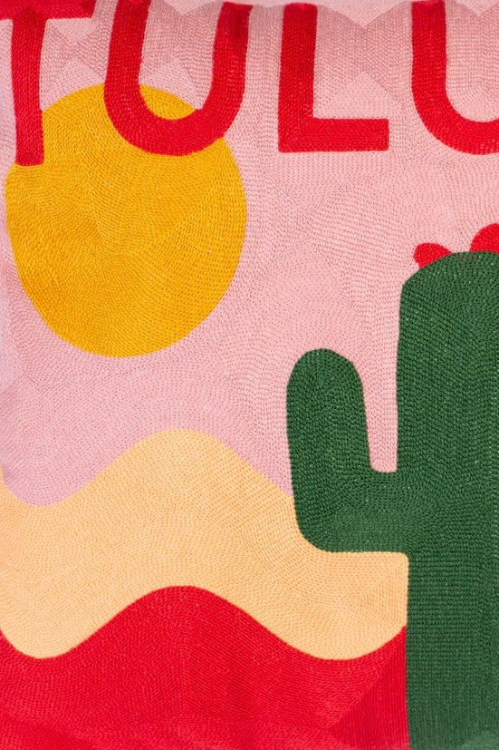 Textile with 'Tulum' text, sun, and cactus design on a pink background