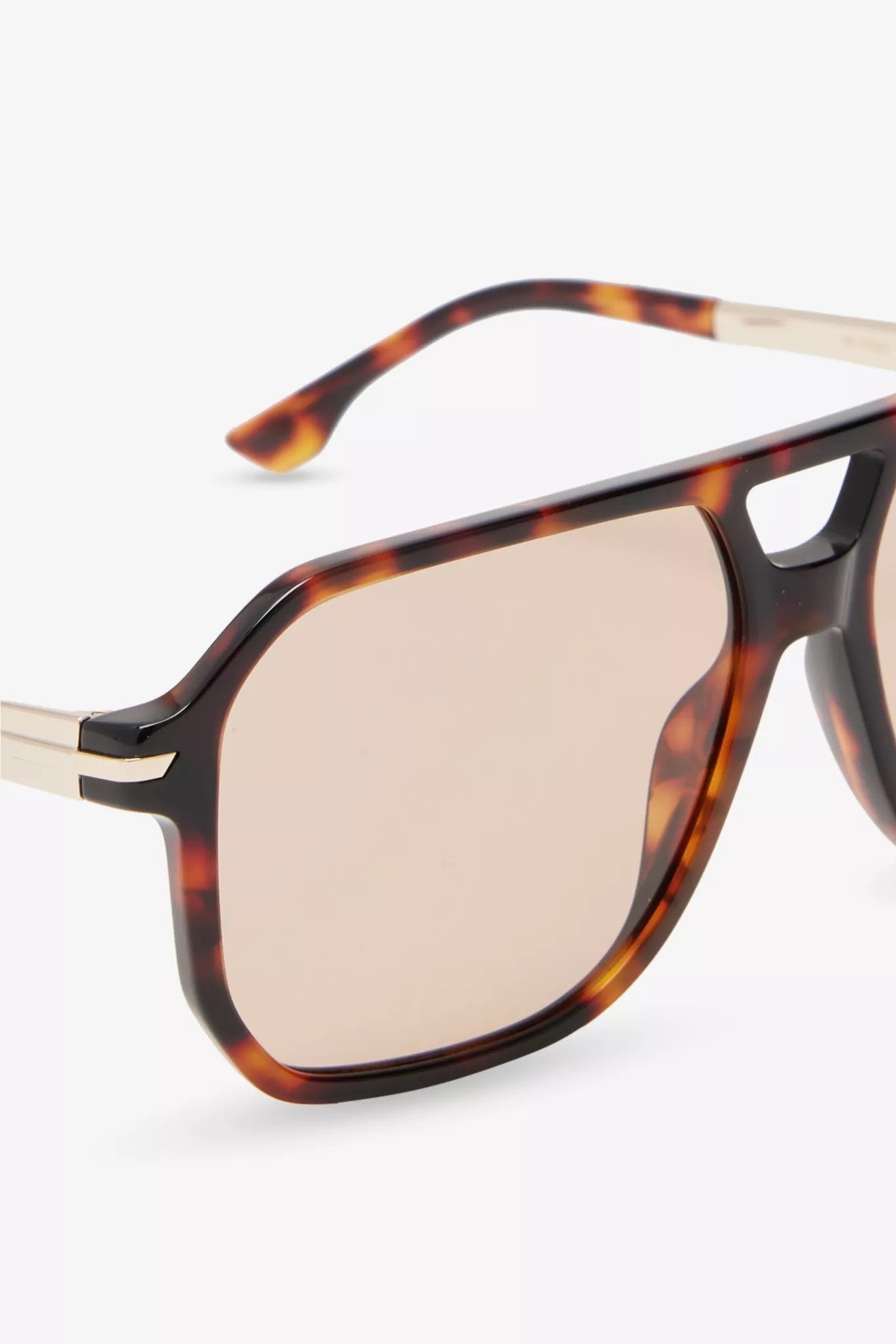 Sunglasses with tortoiseshell frame and gold accents on a white background