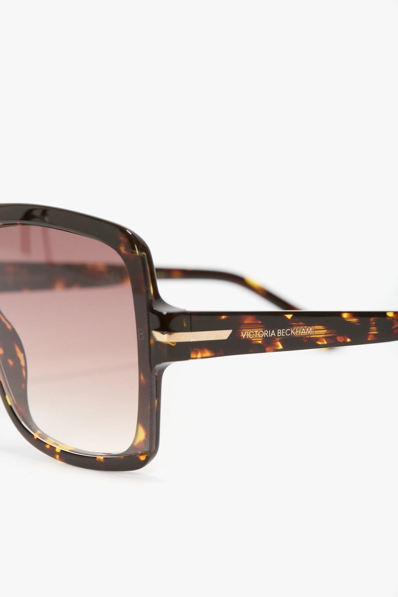 Sunglasses with tortoiseshell frame and brown gradient lenses on a white background