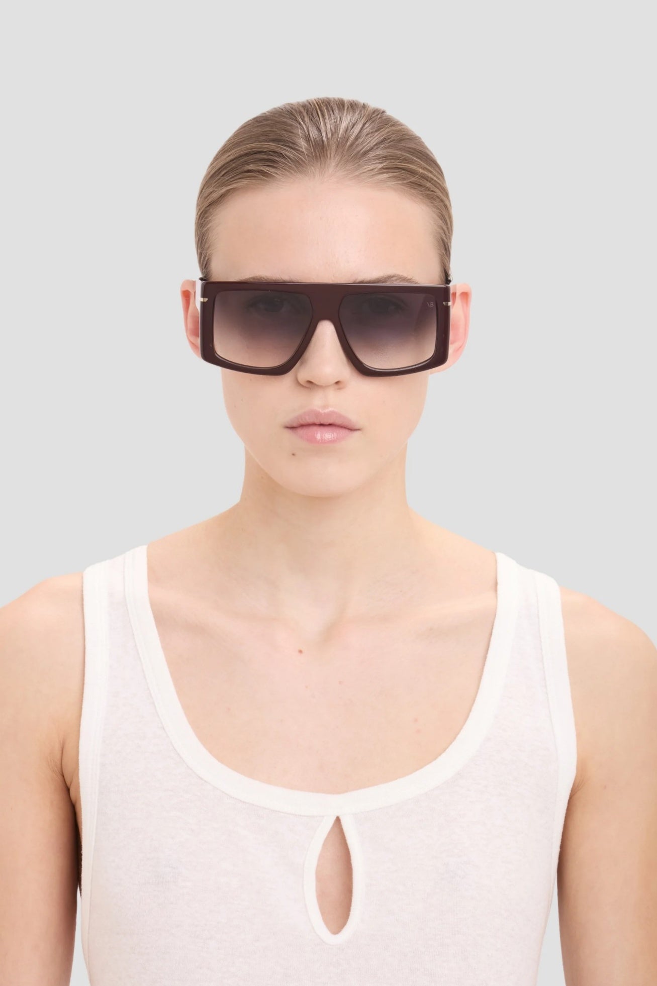 Model wearing a pair of large sunglasses with a plain background