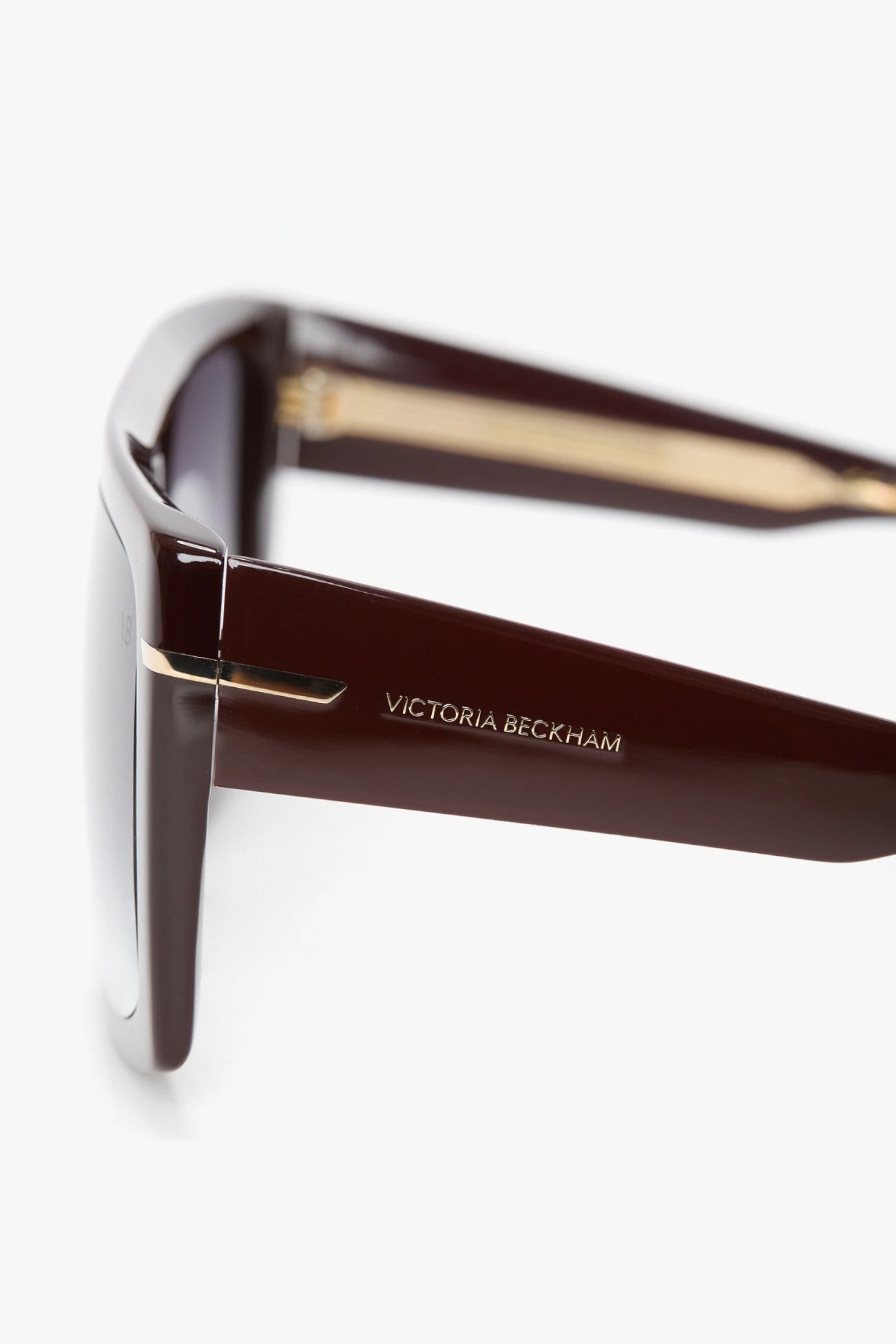 Brown sunglasses with gold accents on a white background, featuring the Victoria Beckham logo.