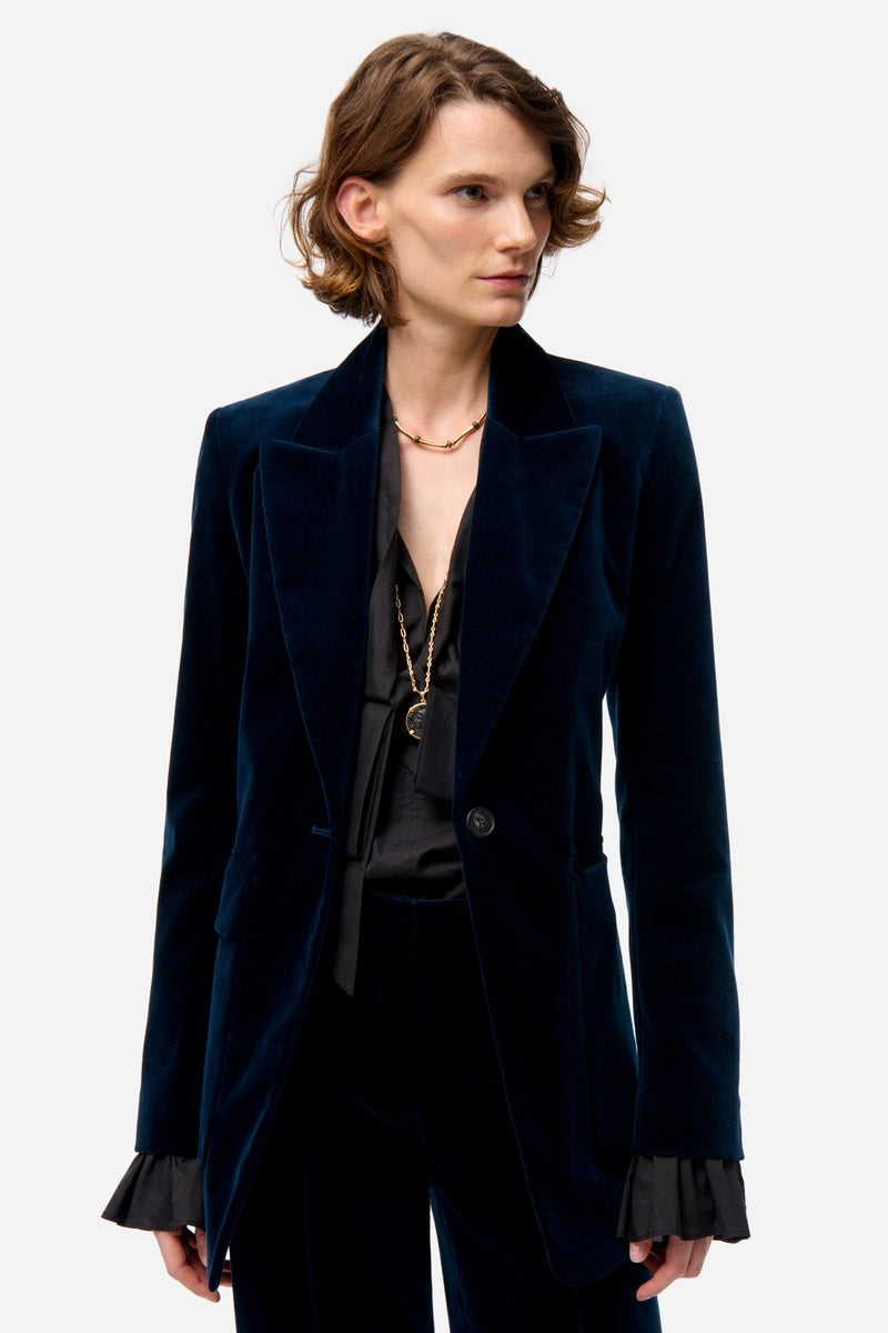 Woman wearing a dark blue velvet blazer on a white background