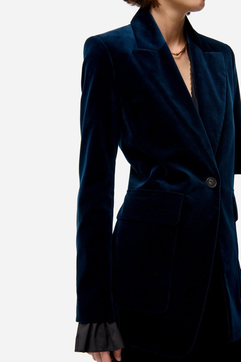 Navy blue velvet blazer worn by a person on a white background
