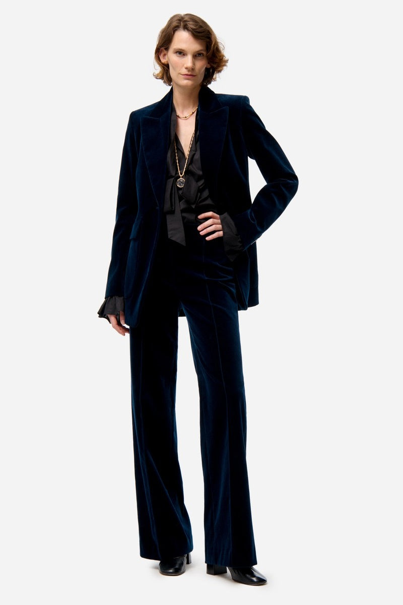 Woman wearing a dark blue velvet suit on a white background
