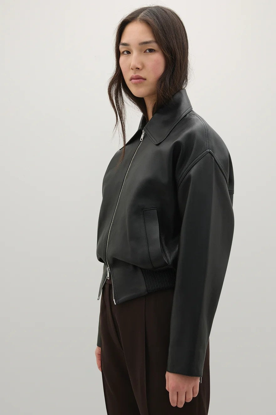 Person wearing a black jacket on a white background