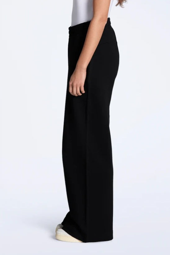 Black wide-leg pants worn by a person on a white background