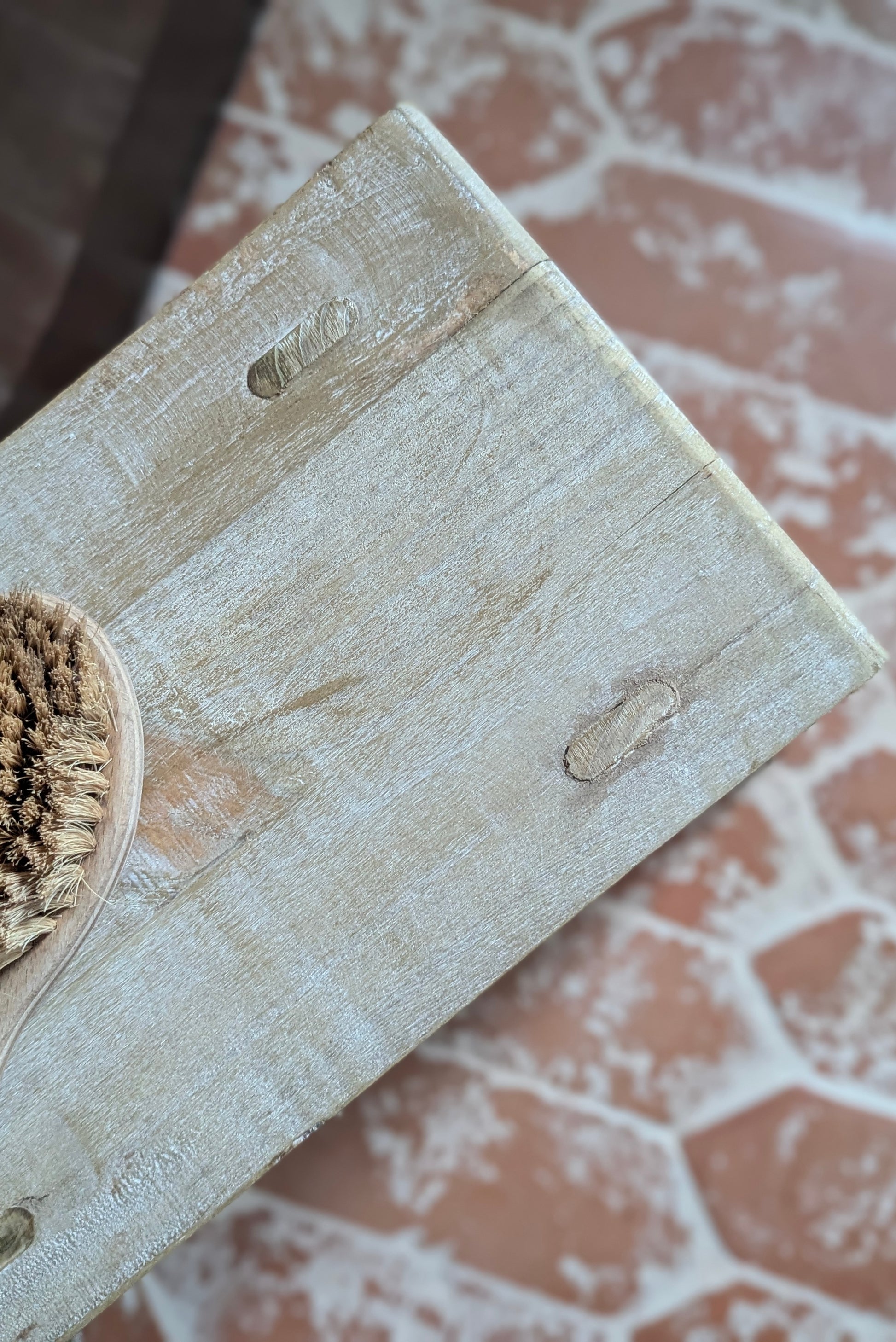 Wooden scrubber with a bristle brush on a textured surface